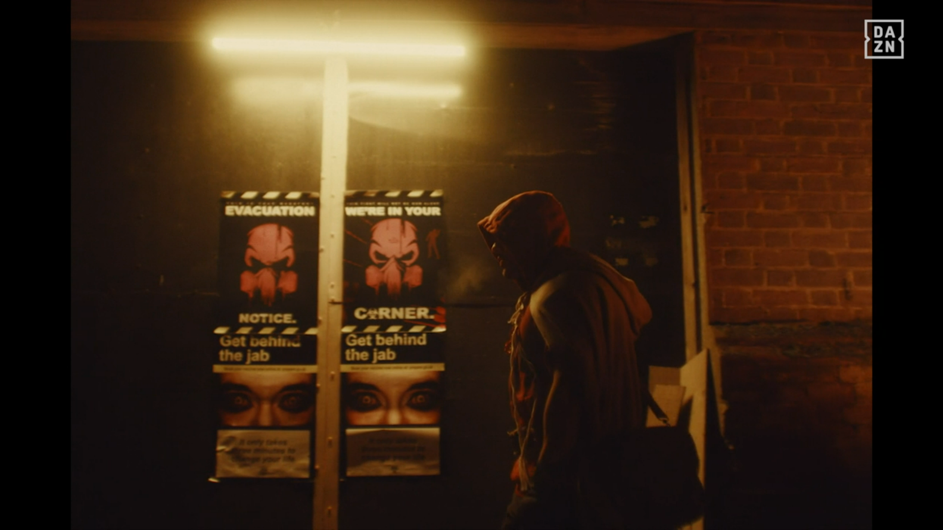 A boxer walks through an alley in an apocolyptic zombie setting, the wall in the background has posters from the authorities that say "WE'RE IN YOUR CORNER", and "Get behind the jab"