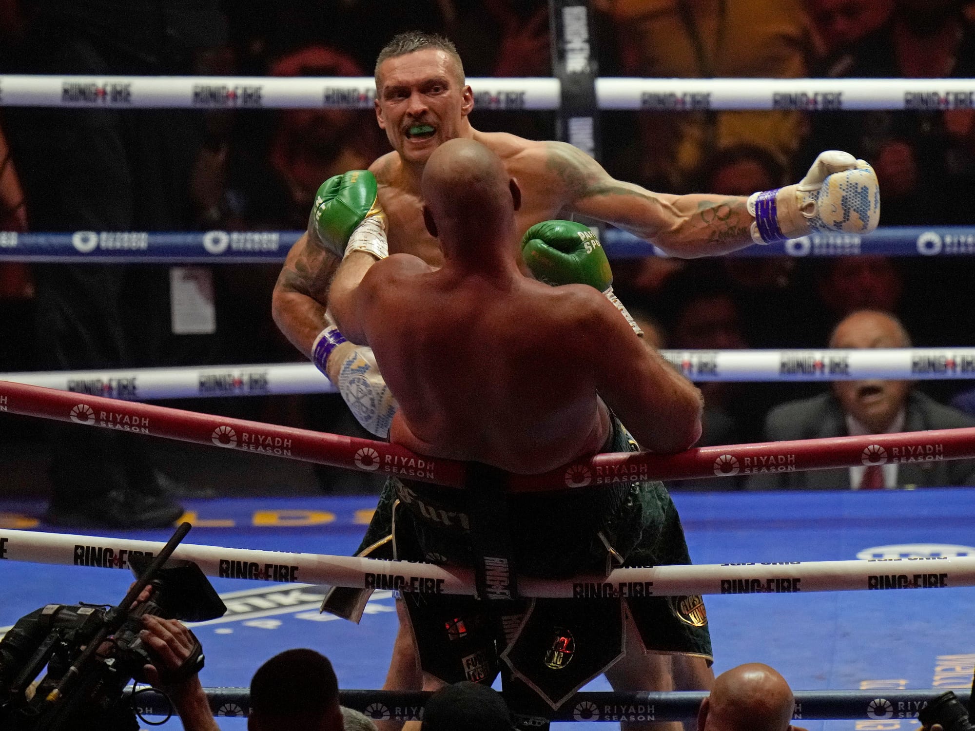 Fury has his back to the camera and is falling backwards over the ropes, he's trying to push Usyk's chest with a left. Usyk, is in the middle of throwing his own left hook (American-style), his arm is almost fully extended and level with Fury's head, his expression is wild. It's a pretty cool photo.