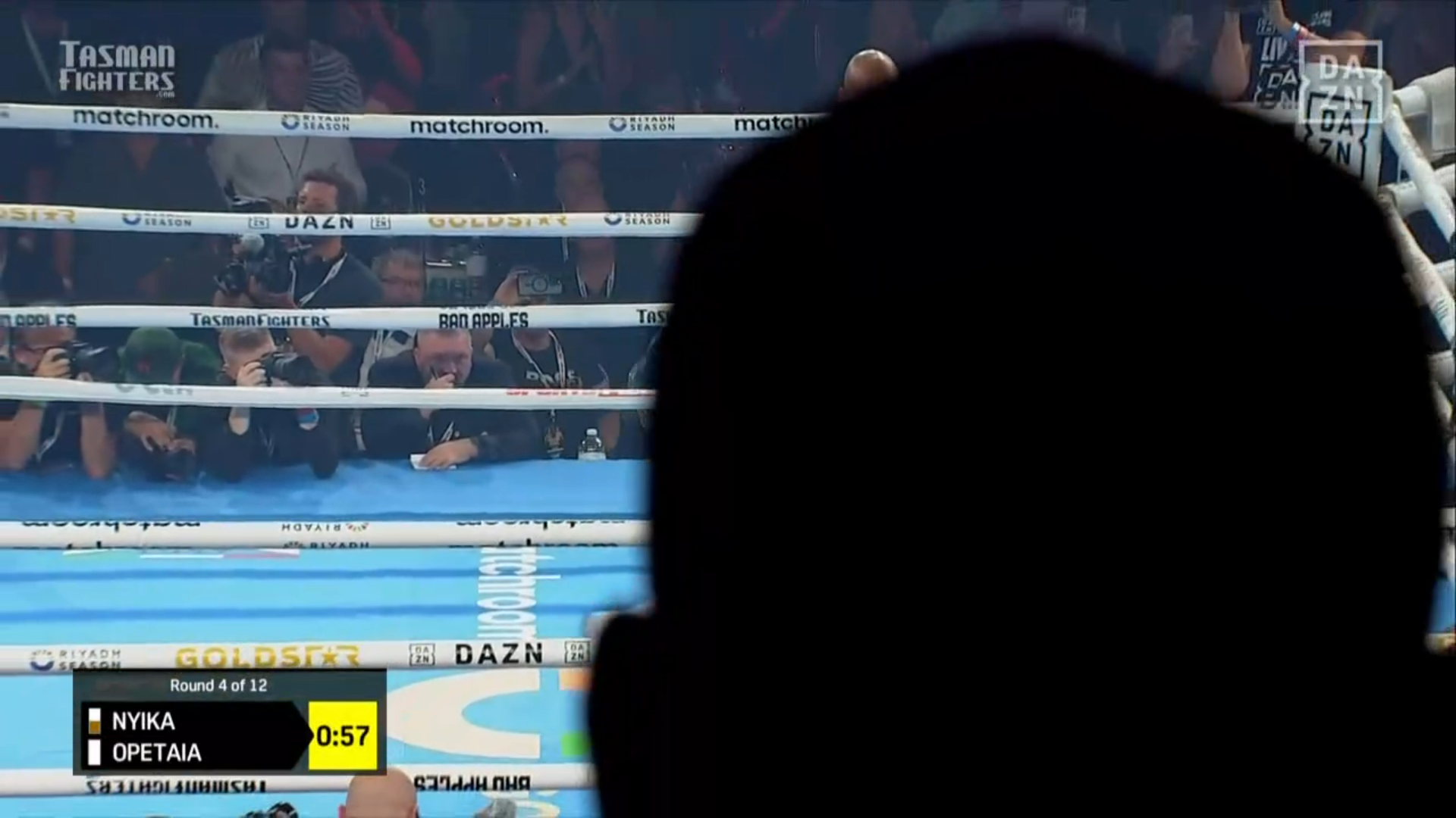 A screenshot of round 4 of Opetaia-Nyika, some guys head is blocking half the screen where both fighters and the referee are