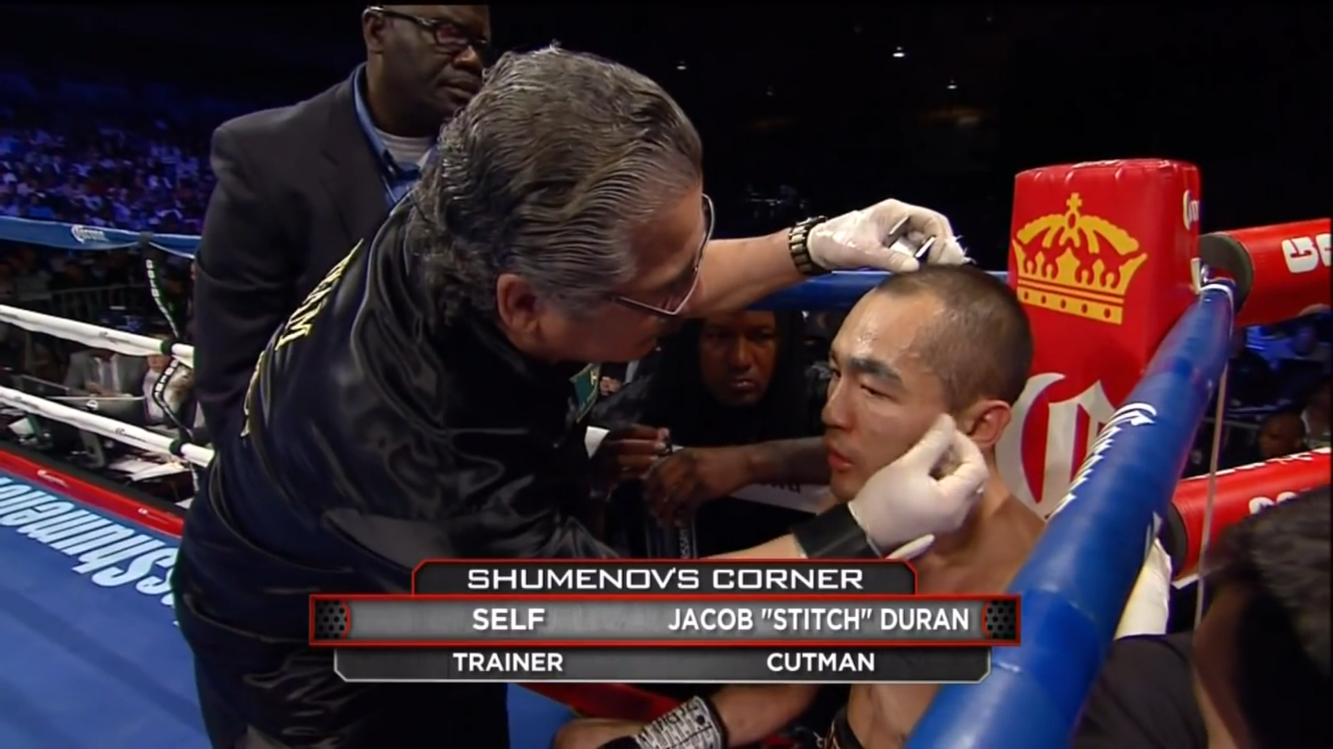 A screenshot of Hopkins-Shumenov, it's Beibut Shumenov in his corner being work on by Jacob "Stich" Duran, the graphic says "TRAINER SELF"